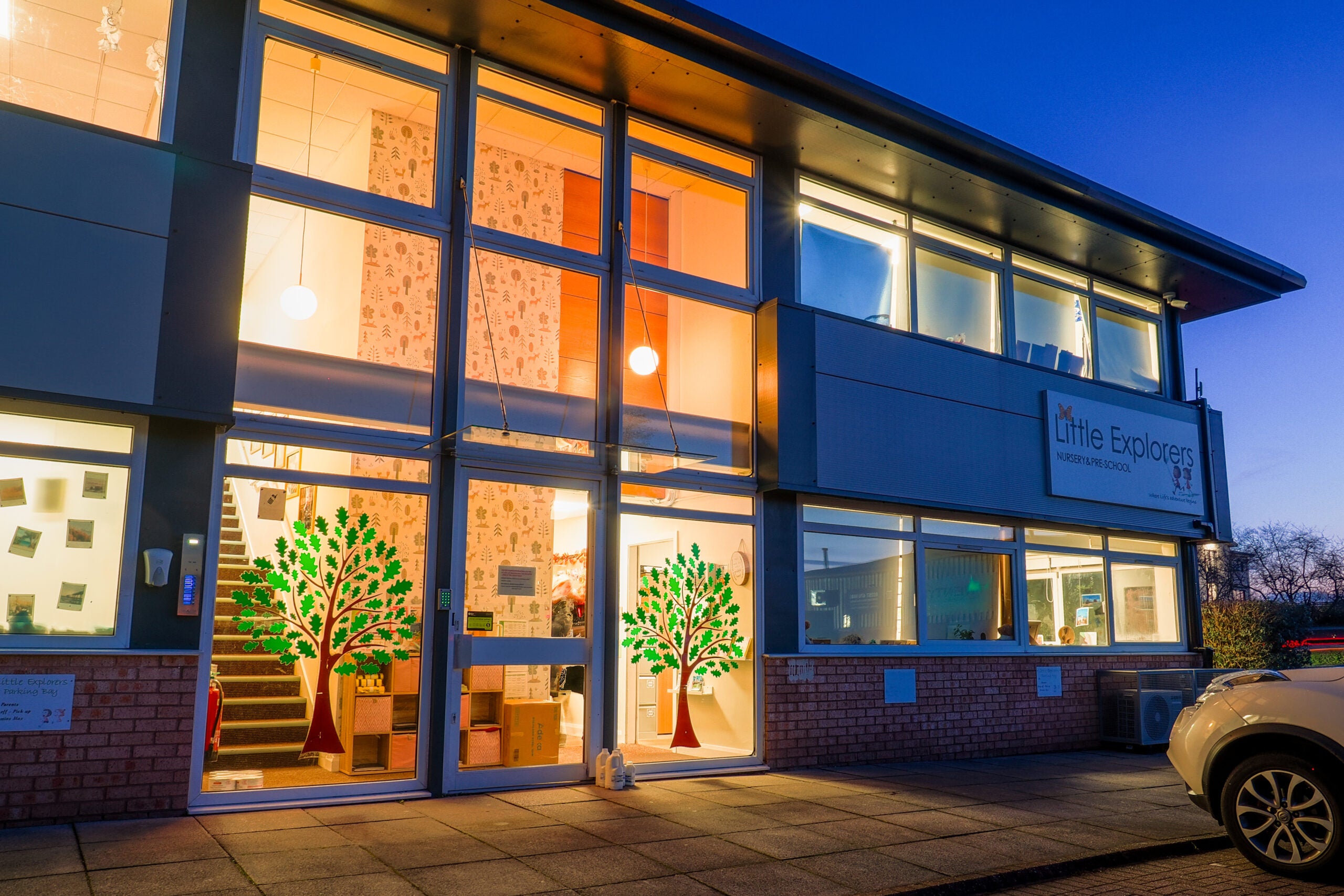 Modern building exterior with large glass windows at dusk