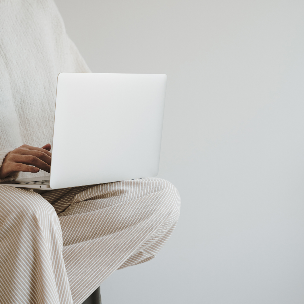 Person using a laptop on a light gray background