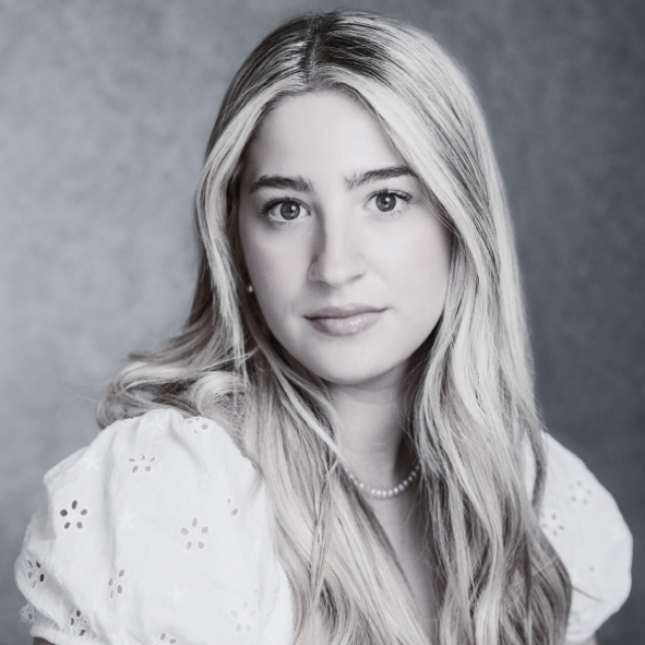 Black and white portrait of a woman with long blonde hair wearing a white blouse.